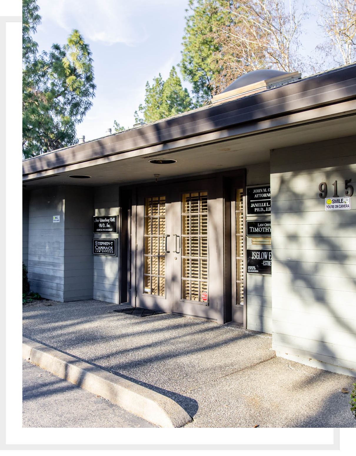 Exterior of a small building with signage and glass double doors.